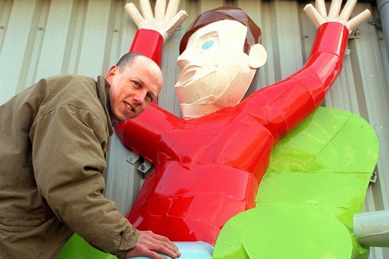 Artist Mike Kirkby-Geddes is pictuered with one of his giant metal figures on the new stand at Batley RL in May 1996.