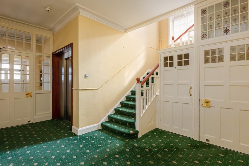 The large entrance hall with stairs and a lift plus stained glass panels