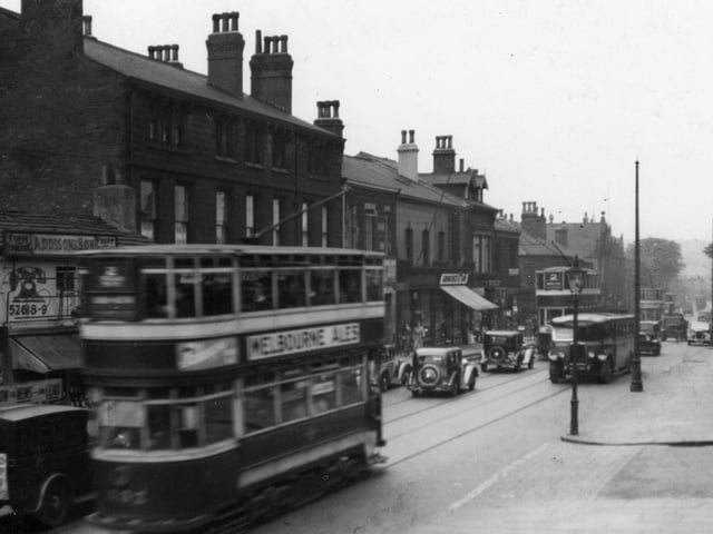 A stretch of Otley Road, looking towards North Lane in June 1937. On the left, with telephone sign on wall is the fish shop of William Addison. Further to the right, shop with blind down is at number 31, Groocock and Son, grocers.