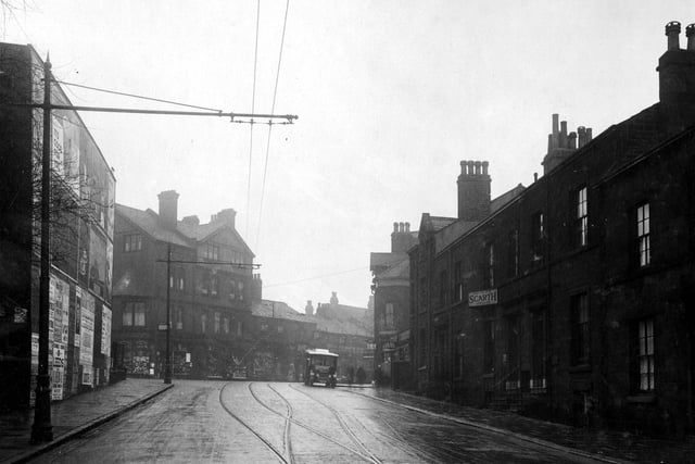Headingley's Victoria Road in February 1930 looking towards Hyde Park Corner. The road is part cobbled and has tram lines. Overhead tram wires can be seen