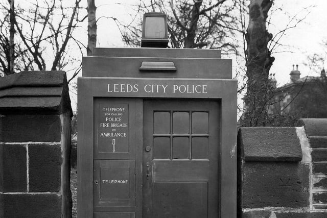 A police telephone box, set into a stone wall, on Headingley Lane in March 1935. The words Leeds City Police are above the door. There is access from the outside for telephone and first aid appliances.