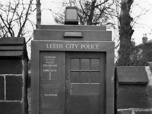 A police telephone box, set into a stone wall, on Headingley Lane in March 1935. The words Leeds City Police are above the door. There is access from the outside for telephone and first aid appliances.