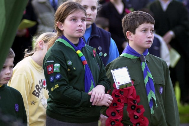 Two Scout members prepare to lay a wreath of poppies.
