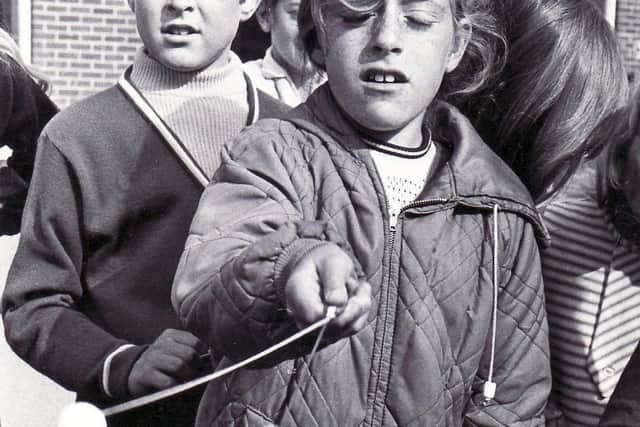 A youngster playing with some clackers in 1971