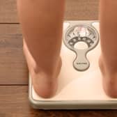 An 11-year-old girl using a set of weighing scales. Picture: Chris Radburn/PA Wire