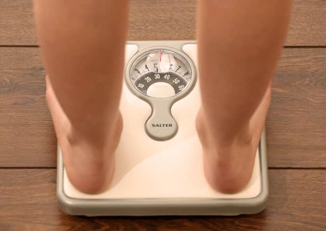 An 11-year-old girl using a set of weighing scales. Picture: Chris Radburn/PA Wire