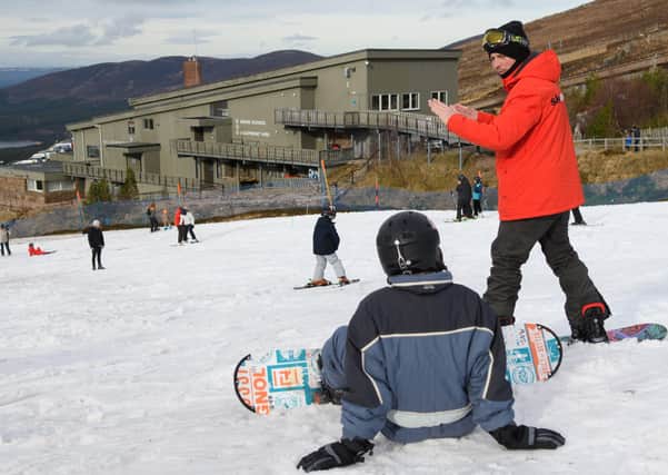 A snowboard lesson at Cairngorm Mountain, with the Funicular base station in the background