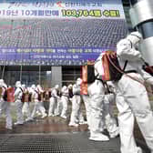 Soldiers wearing protective suits spray disinfectant to prevent the spread of the coronavirus in front of a church in Daegu, South Korea (Picture: Lee Moo-ryul/Newsis via AP)