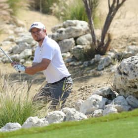 Eddie Pepperell plays out of the rocks at the third hole during the first day of the Qatar Masters. He was later disqualified. Picture: Warren Little/Getty Images