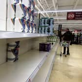 The shelves of a supermarket in Edinburgh emptied of toilet rolls by anxious shoppers