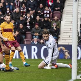Conor Washington, grounded, slides in to score Hearts’ equaliser against Motherwell. Picture: SNS