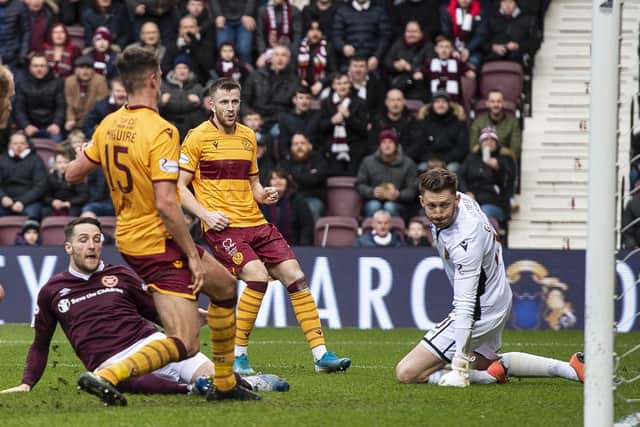 Conor Washington, grounded, slides in to score Hearts’ equaliser against Motherwell. Picture: SNS