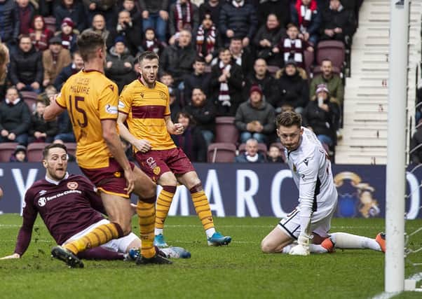 Conor Washington, grounded, slides in to score Hearts’ equaliser against Motherwell. Picture: SNS