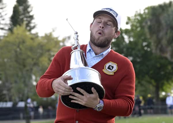 Englishman Tyrrell Hatton shows what winning the Arnold Palmer Invitational means to him after getting his hands on the trophy. Picture: AP.