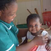 Looking after a baby girl at the Open Arms Blantyre Infant Home in Malawi
