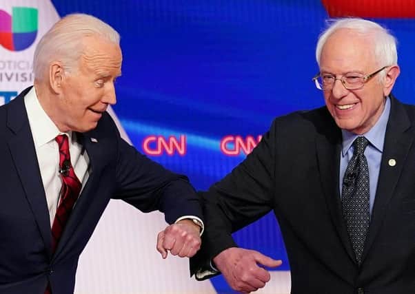 Joe Biden, seen elbow-bumping with Bernie Sanders, has struggled to make his voice heard amid the coronavirus crisis (Picture: Mandel Ngan/AFP via Getty Images)