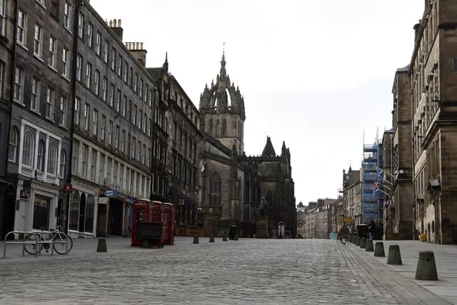 Many normally busy streets - such as Edinburgh's High Street - are now virtually empty as the coronavirus lockdown takes hold. Picture: Lisa Ferguson