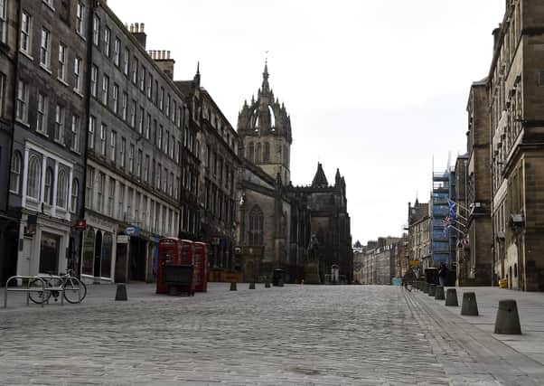 Many normally busy streets - such as Edinburgh's High Street - are now virtually empty as the coronavirus lockdown takes hold. Picture: Lisa Ferguson