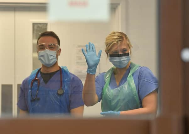 NHS staff wearing a degree of personal protective equipment (PPE) wait to receive coronavirus patients (Picture: Jacob King/PA Wire)