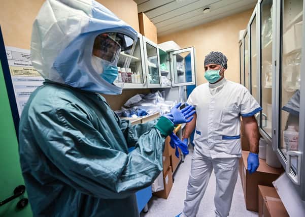 Some personal protective equipment (PPE) is better than others: the nurse on the left is getting ready to start work in an intensive care unit for Covid-19 patients in a hospital in Rome (Picture: Andreas Solaro/AFP via Getty Images)