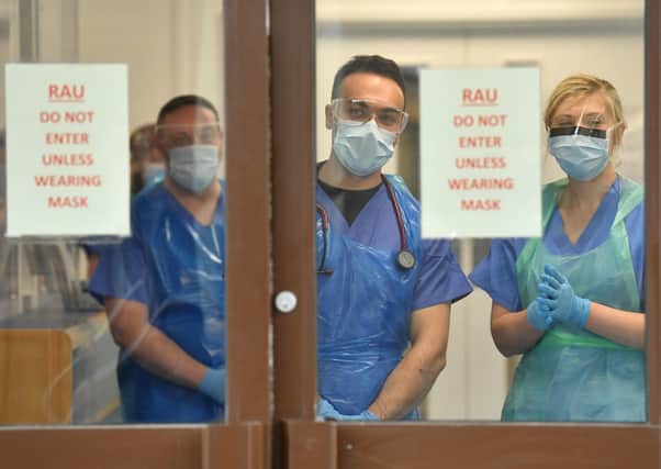 Medical staff wearing personal protective equipment (PPE) wait to receive coronavirus patients at the door of the Respiratory Assessment Unit at the Morriston Hospital in Swansea. Picture: PA