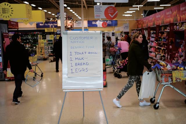 A board displays shopping restrictions at a Tesco supermarket in Warrington after spates of panic buying cleared shelves