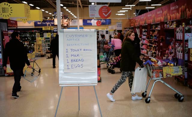 A board displays shopping restrictions at a Tesco supermarket in Warrington after spates of panic buying cleared shelves