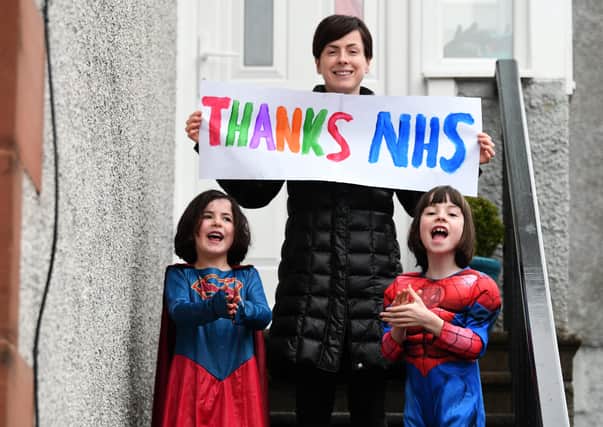 A family joins in the applause for the NHS in Glasgow (Picture: John Devlin)