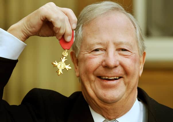 Tim Brooke-Taylor holds up the OBE presented to him by Prince Charles in 2011 (Picture: John Stillwell - WPA Pool/Getty Images)