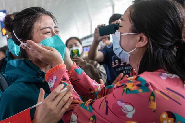 A medical staff member from Peking Union Medical College Hospital, left, tears up as she prepares to leave Wuhan, but was China's government slow to act over the virus? (Picture: STR/AFP via Getty Images)