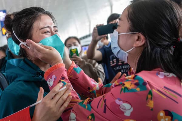 A medical staff member from Peking Union Medical College Hospital, left, tears up as she prepares to leave Wuhan, but was China's government slow to act over the virus? (Picture: STR/AFP via Getty Images)