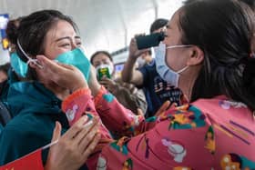 A medical staff member from Peking Union Medical College Hospital, left, tears up as she prepares to leave Wuhan, but was China's government slow to act over the virus? (Picture: STR/AFP via Getty Images)