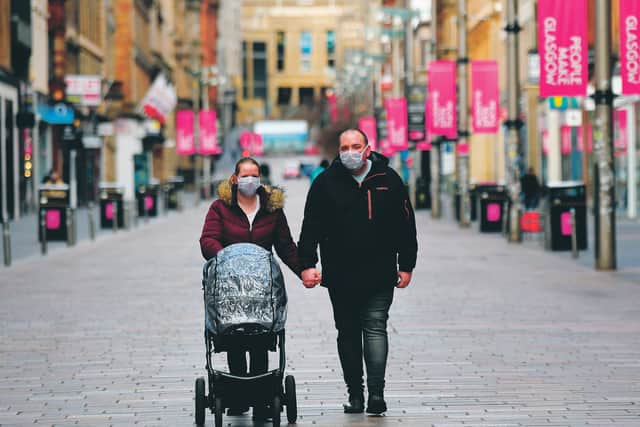 A family walk along an empty Buchanan Street in Glasgow city centre after the coronavirus lockdown saw much of the country's shops close. Picture: John Devlin