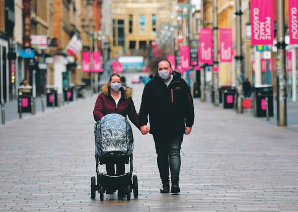A family walk along an empty Buchanan Street in Glasgow city centre after the coronavirus lockdown saw much of the country's shops close. Picture: John Devlin