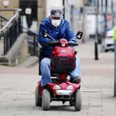 A man drives a mobility scooter while wearing a face mask through Falkirk