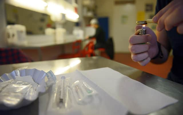 A heroin addict cooks a heroin dose in a room at the Konsumraume (consumption room) in Berlin. Picture: Getty Images