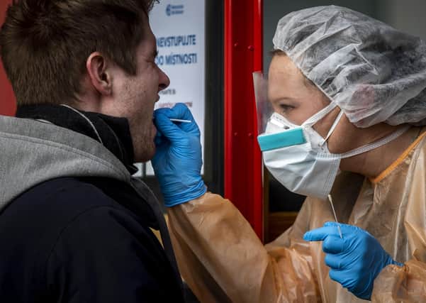 A medic takes a sample to test a patient possibly infected with coronavirus at the Na Bulovce hospital in Prague, Czech Republic where the government has declared a 30-day state of emergency. Picture: Getty