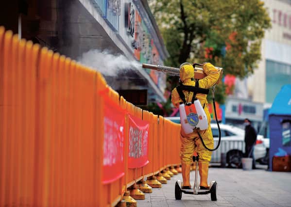 An isolated residential area is sprayed with disinfectant in Wuhan. Picture: STR/Getty