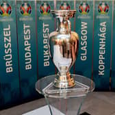The European Championship trophy sits in front of the names of all the planned host cities for 2020 with the event now having been postponed by a year. Picture: Attila Kisbenedek/AFP via Getty