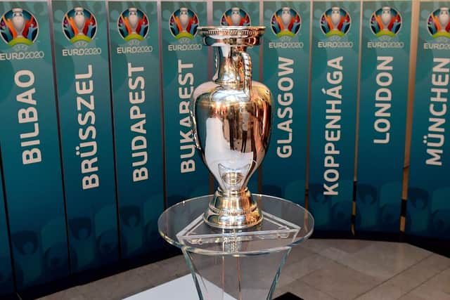 The European Championship trophy sits in front of the names of all the planned host cities for 2020 with the event now having been postponed by a year. Picture: Attila Kisbenedek/AFP via Getty