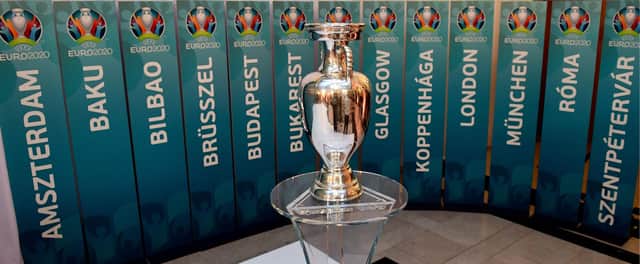 The European Championship trophy sits in front of the names of all the planned host cities for 2020 with the event now having been postponed by a year. Picture: Attila Kisbenedek/AFP via Getty