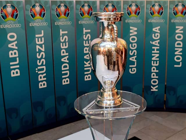 The European Championship trophy sits in front of the names of all the planned host cities for 2020 with the event now having been postponed by a year. Picture: Attila Kisbenedek/AFP via Getty