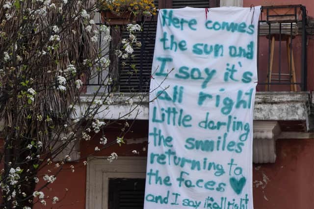 A banner with lyrics from the Beatles' song "Here comes the sun" hangs from a balcony in Rome (Picture: AFP via Getty Images)