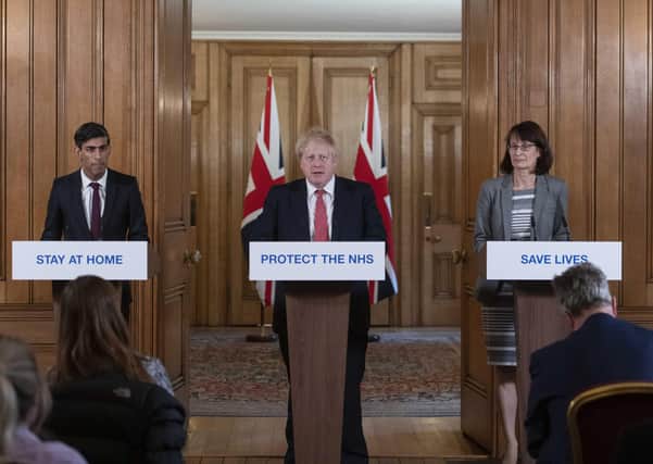 Boris Johnson, centre, Chancellor Rishi Sunak, left and Deputy Chief Medical officer for England Jenny Harries take part in a Coronavirus press conference, in Downing Street
