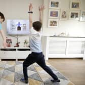 Ben and Isaac Rickett follow PE with Joe, a fitness workout by Joe Wicks that is aimed at children that are being home schooled due to Covid-19. Picture: Martin Rickett/PA Wire