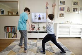 Ben and Isaac Rickett follow PE with Joe, a fitness workout by Joe Wicks that is aimed at children that are being home schooled due to Covid-19. Picture: Martin Rickett/PA Wire