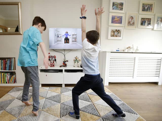 Ben and Isaac Rickett follow PE with Joe, a fitness workout by Joe Wicks that is aimed at children that are being home schooled due to Covid-19. Picture: Martin Rickett/PA Wire
