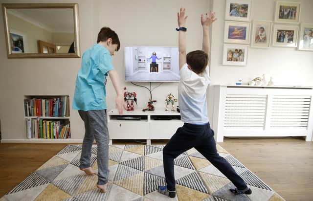 Ben and Isaac Rickett follow PE with Joe, a fitness workout by Joe Wicks that is aimed at children that are being home schooled due to Covid-19. Picture: Martin Rickett/PA Wire