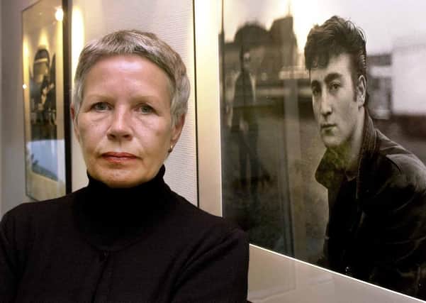 Astrid Kirchherr posing next to one of her images of John Lennon.(Picture: Ulrich Perrey, DPA via AP, File)