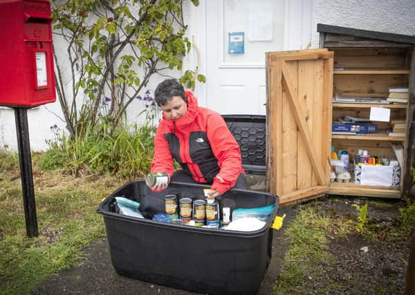 Becs Barker checks the donations left in the "swap shop" box in Minard, Argyll and Bute.